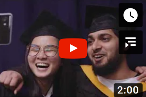 two students smiling each other in the graduation attire